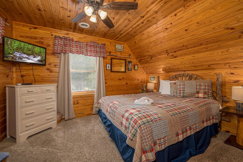 Drift off to sleep in your cozy log cabin bedroom, wrapped in rustic warmth with plaid linens and mountain charm.