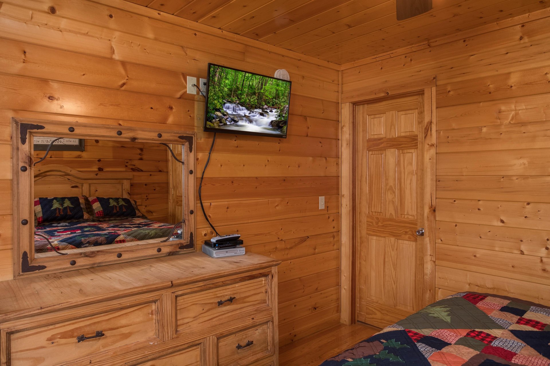 Dresser, mirror, and TV in a bedroom Kick Back  Relax A 4 bedroom cabin rental located in Pigeon Forge