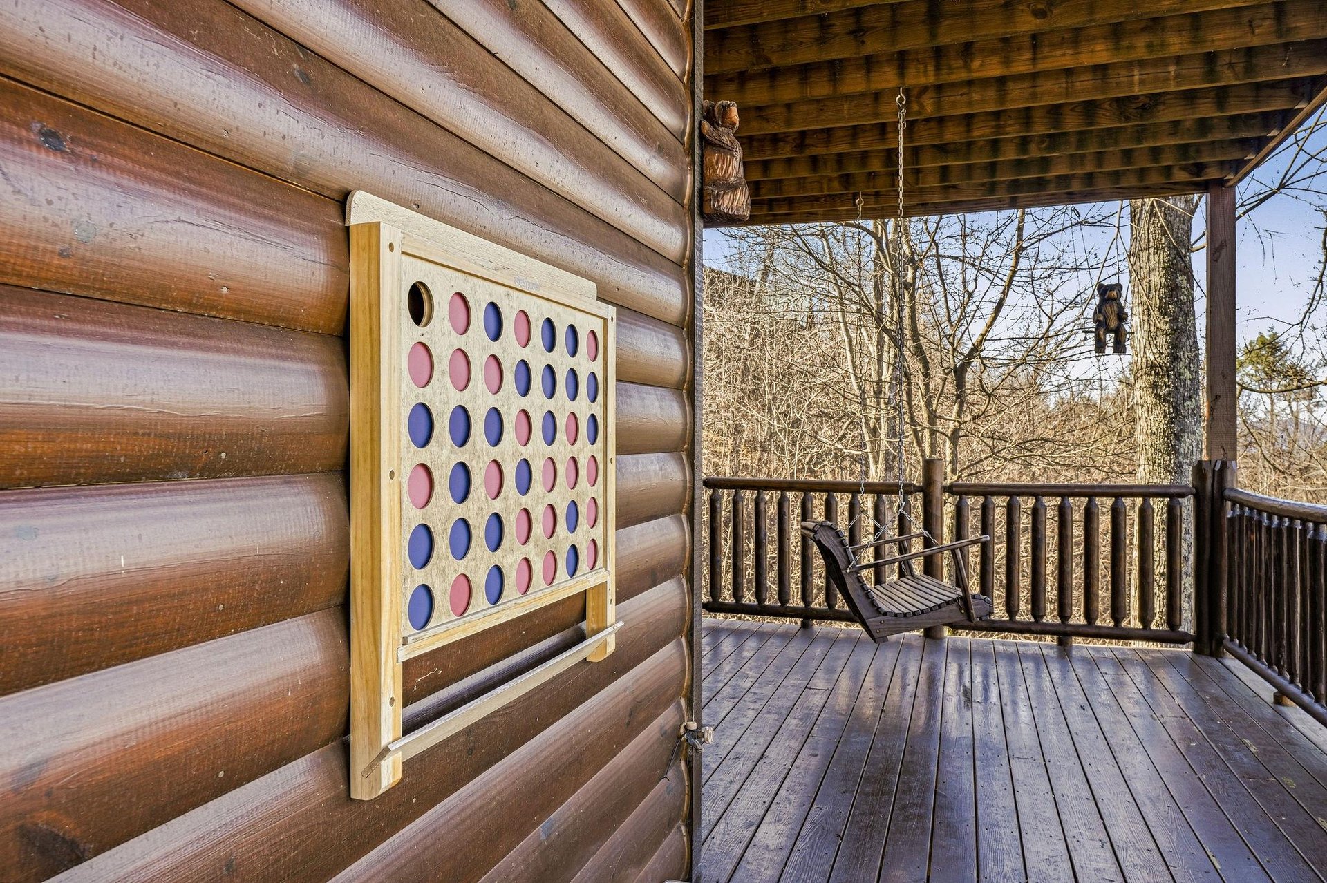 Unwind on your private deck where a giant Connect Four game awaits friendly competition amid peaceful woodland views.