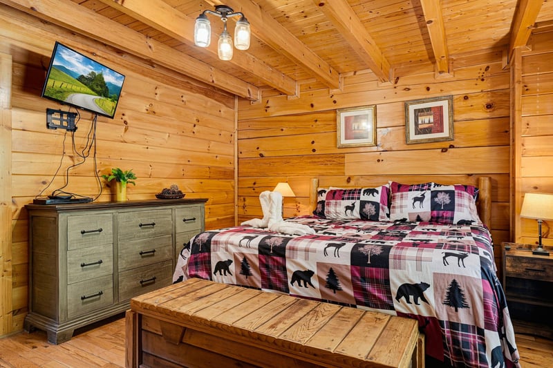 Sink into the plush bed surrounded by warm pine walls and beams, letting the cozy cabin ambiance wrap around you after a day of adventure.