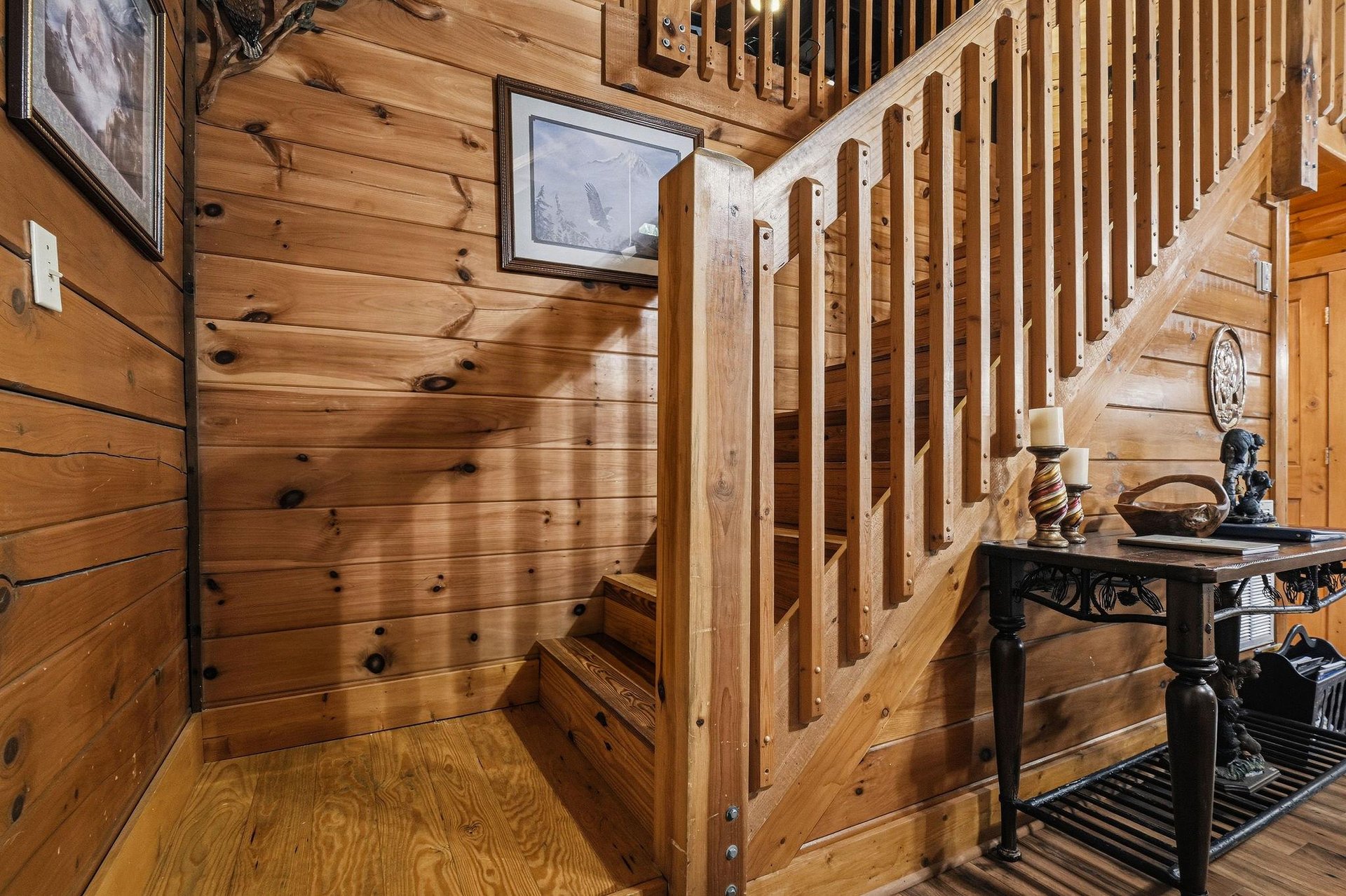 Step into rustic charm with warm knotty pine walls and a handcrafted staircase leading to your private retreat above. This cozy nook sets the tone for your mountain escape.