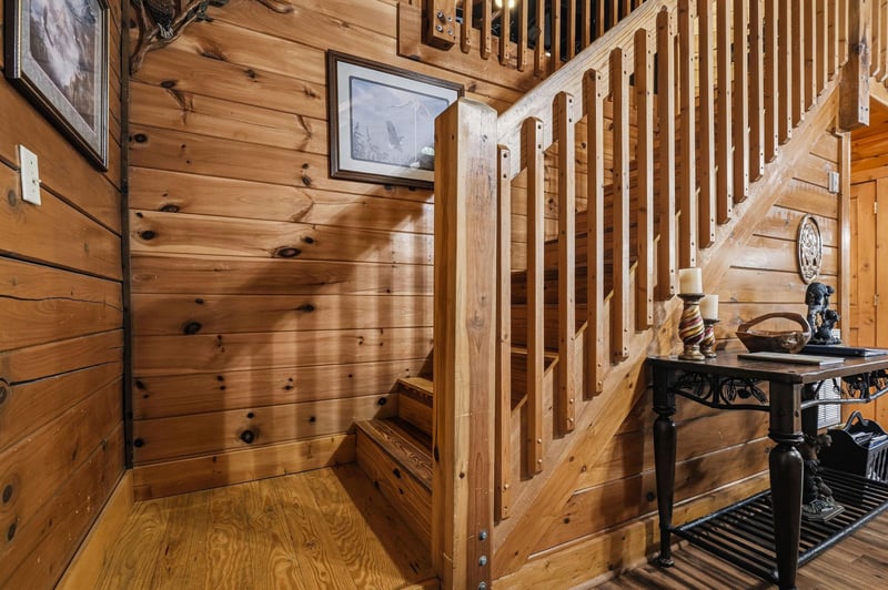 Step into rustic charm with warm knotty pine walls and a handcrafted staircase leading to your private retreat above. This cozy nook sets the tone for your mountain escape.
