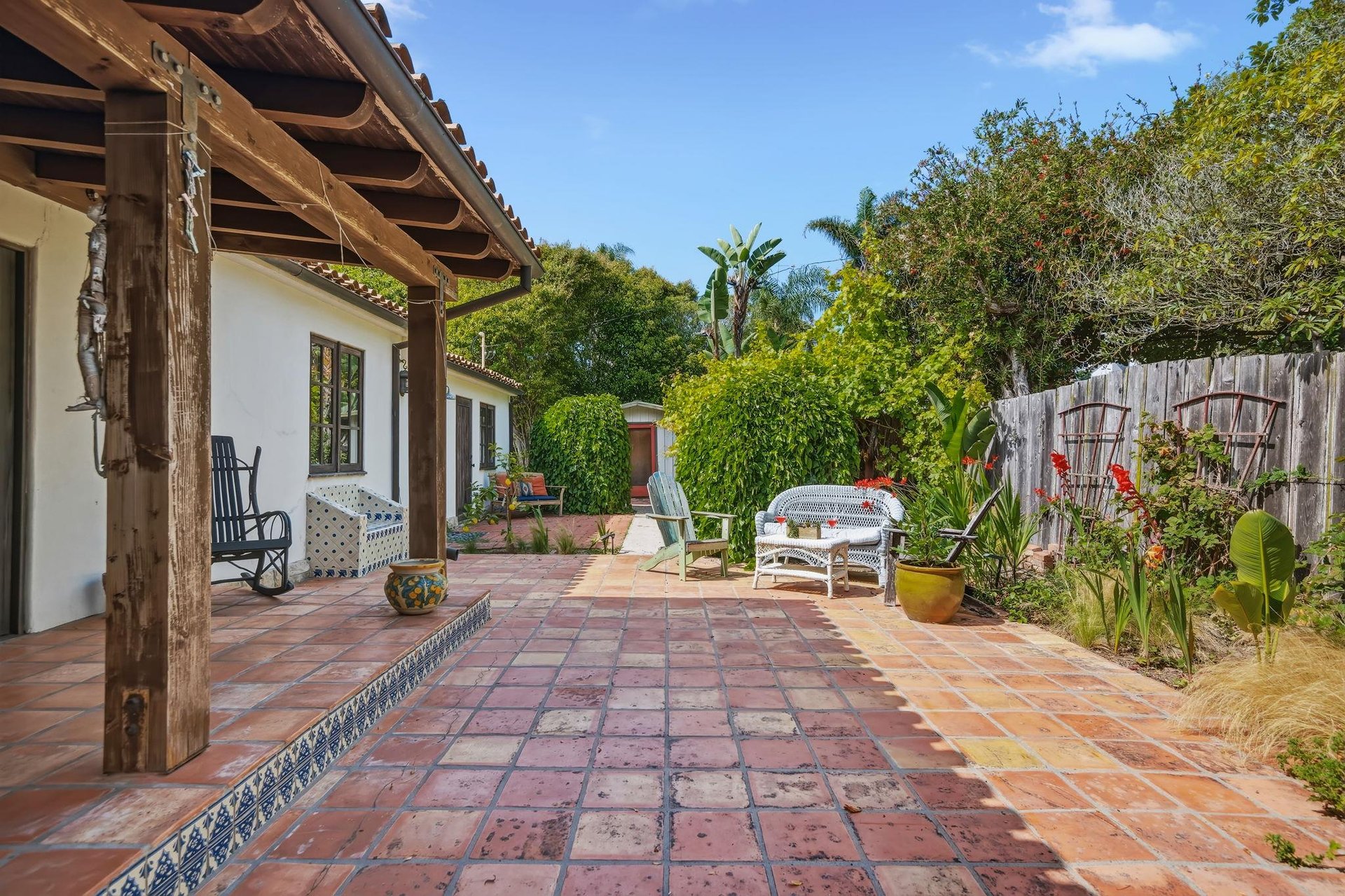 Stunning patio with mosaic tiles, outdoor seating, and an outdoor shower.