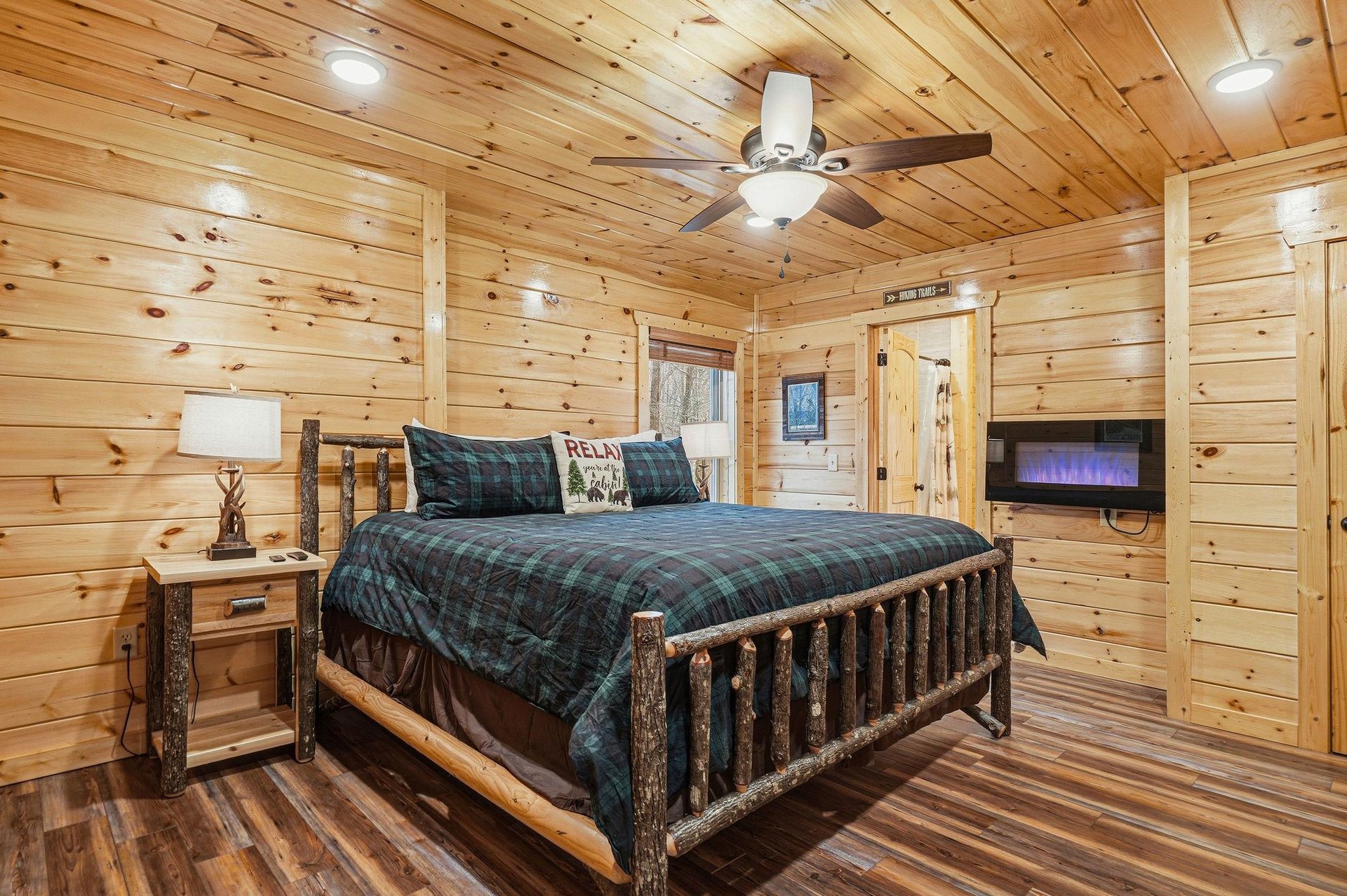 Snuggle into your cozy cabin retreat with rustic log walls and plaid bedding that creates the perfect mountain getaway atmosphere.