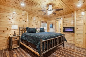 Snuggle into your cozy cabin retreat with rustic log walls and plaid bedding that creates the perfect mountain getaway atmosphere.