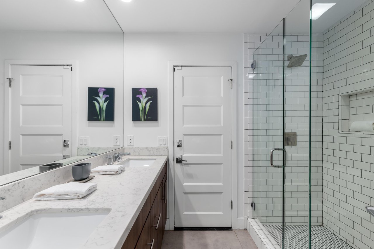 Features a dual vanity sink and walkin shower.