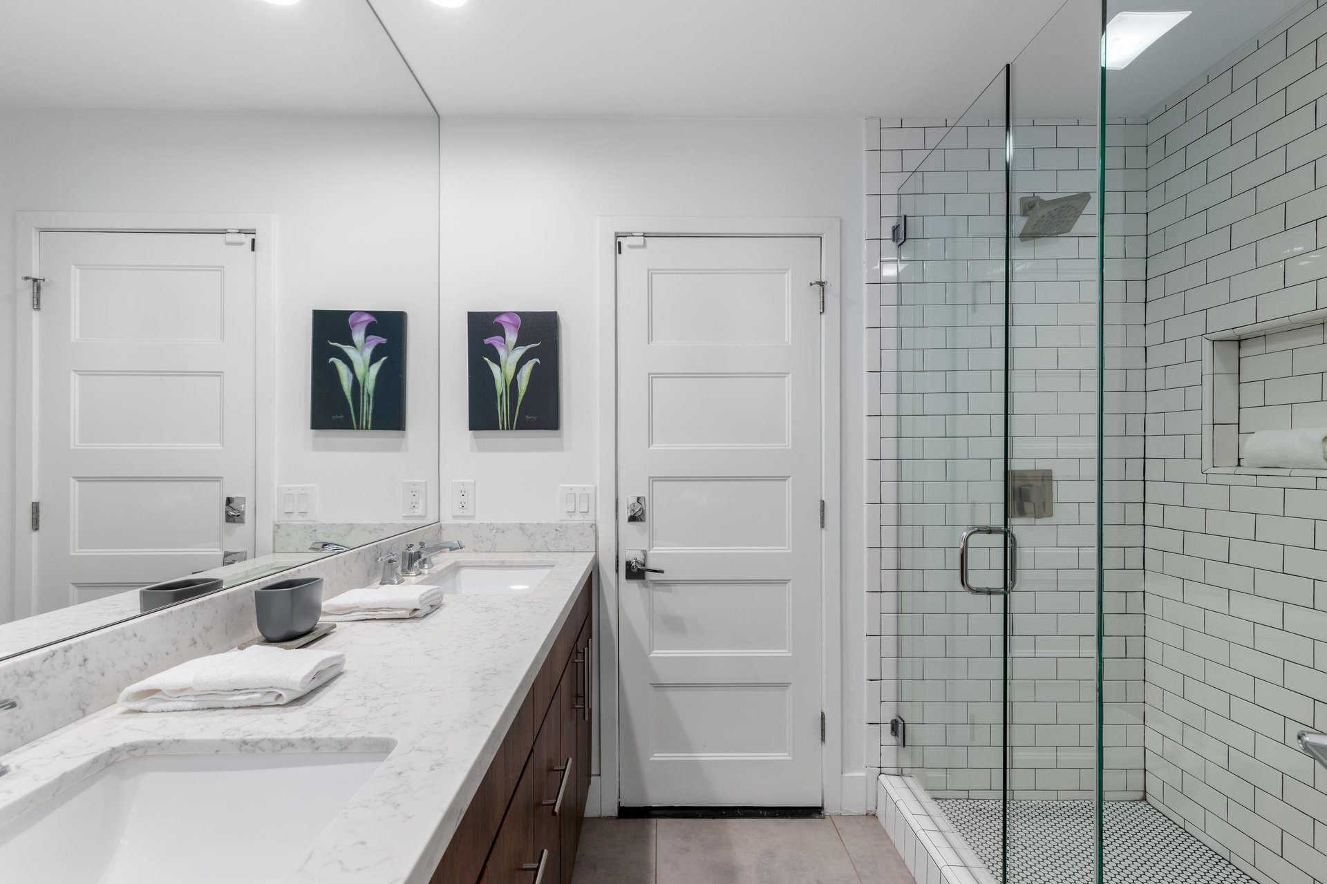 Features a dual vanity sink and walkin shower.