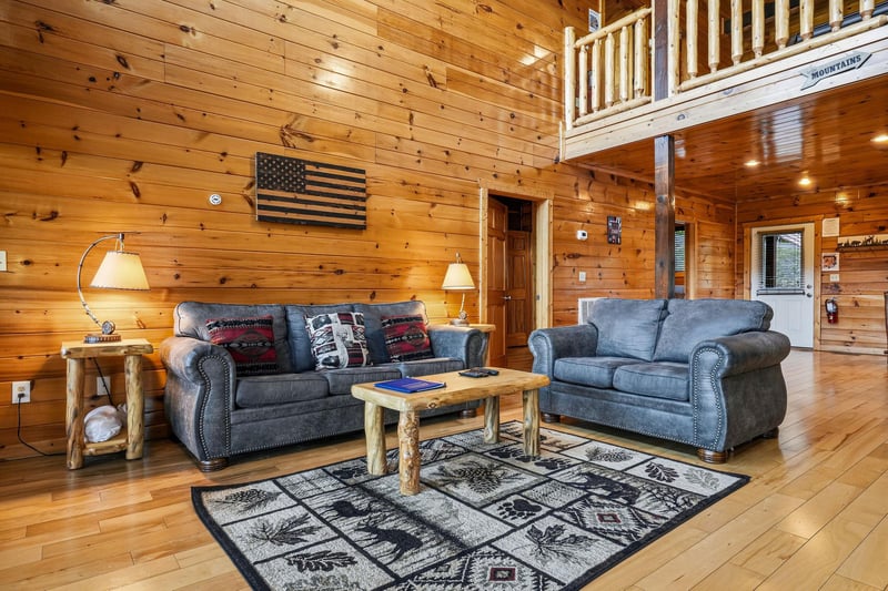 Relax in your cozy cabin living room with rustic wood details, plush sofas, and charming mountain décor that welcomes you home after a day of adventure.