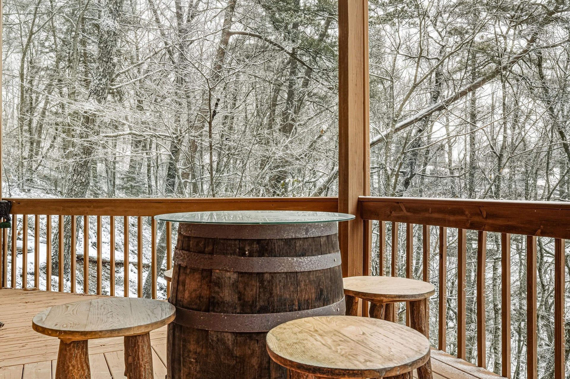 Step onto your private deck where rustic barrel seating overlooks a peaceful winter wonderland of snowladen trees.