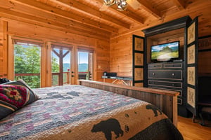 Wake up to stunning mountain vistas through your private balcony doors. Rustic wood beams and cozy quilts create the perfect retreat after a day exploring the peaks.