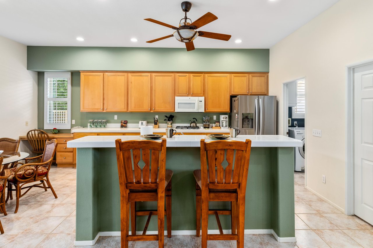 Stainless steel appliances, island with counter seating for 2, and cooking essentials.