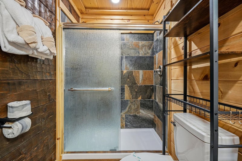 Step into your private spalike retreat, where natural stone meets warm wood in perfect harmony. The spacious walkin shower invites you to unwind after a day of adventure.