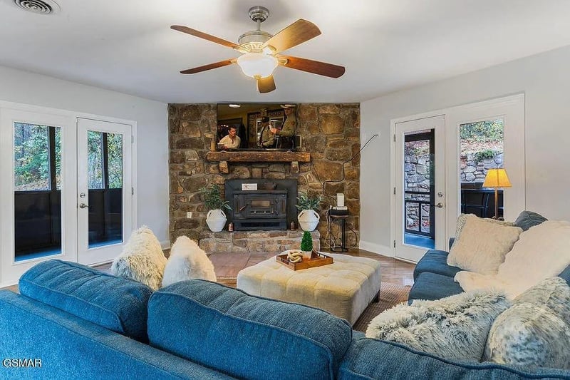 Unwind by your stone fireplace with plush seating and natural light streaming through French doors to your private outdoor space.