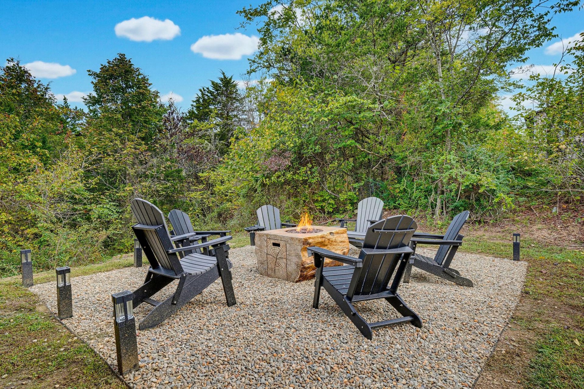 Gather around the fire pit under open skies, where crackling flames and Adirondack chairs set the scene for storytelling and smores beneath the trees.