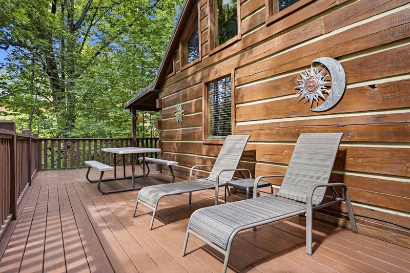 Relax on your private deck surrounded by towering trees. Two lounge chairs invite morning coffee or evening stargazing, with a picnic table ready for al fresco meals in this peaceful forest setting.