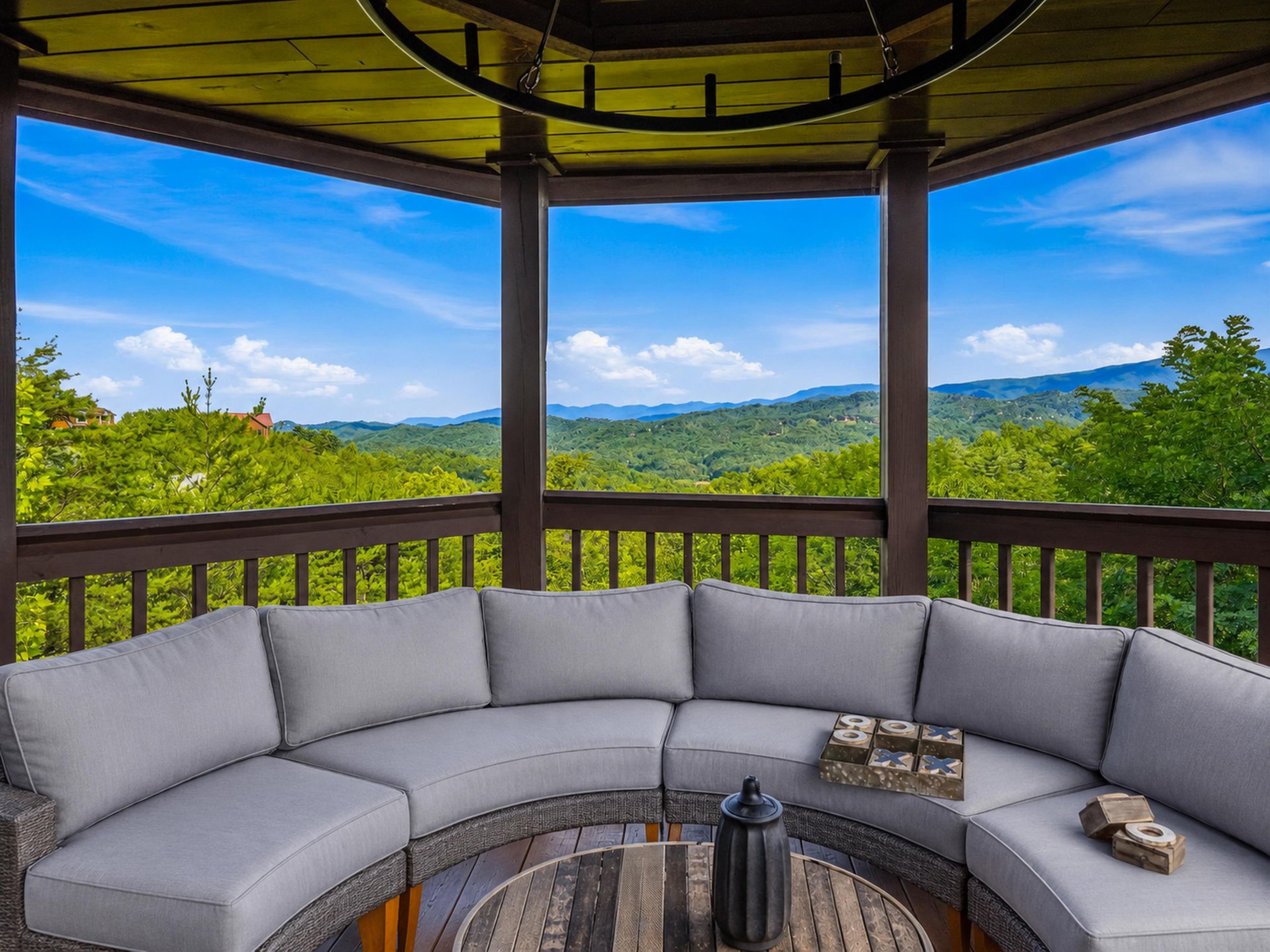 Sweeping mountain vistas frame this covered outdoor seating area, offering a peaceful retreat where you can unwind and soak in the natural beauty of the surrounding landscape.