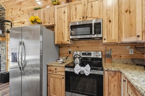 Your fully equipped kitchen welcomes you with warm wood cabinets and modern appliances for memorable meals together.