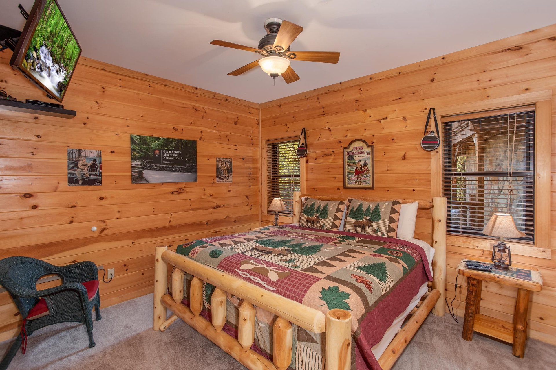 Bedroom with a kingsized log bed and TV at Great View Lodge, a 5bedroom cabin rental located in Pigeon Forge