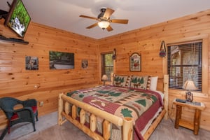 Bedroom with a kingsized log bed and TV at Great View Lodge, a 5bedroom cabin rental located in Pigeon Forge