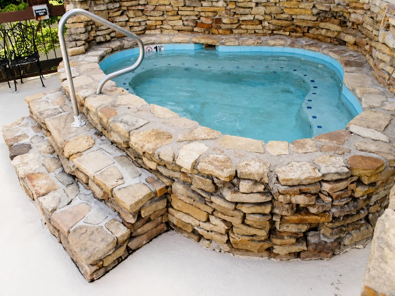 Sink into the soothing warmth of your private hot tub, beautifully framed by natural stacked stone that blends rustic charm with pure relaxation.
