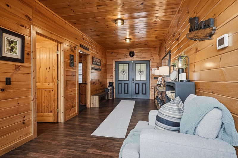 Step into your cozy cabin retreat where warm wood wraps around you and rustic charm welcomes you home—complete with a plush sofa perfect for relaxing after mountain adventures.