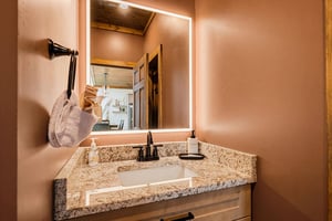 Freshen up at your private vanity, where warm lighting and granite countertops set the tone for a relaxing retreat.