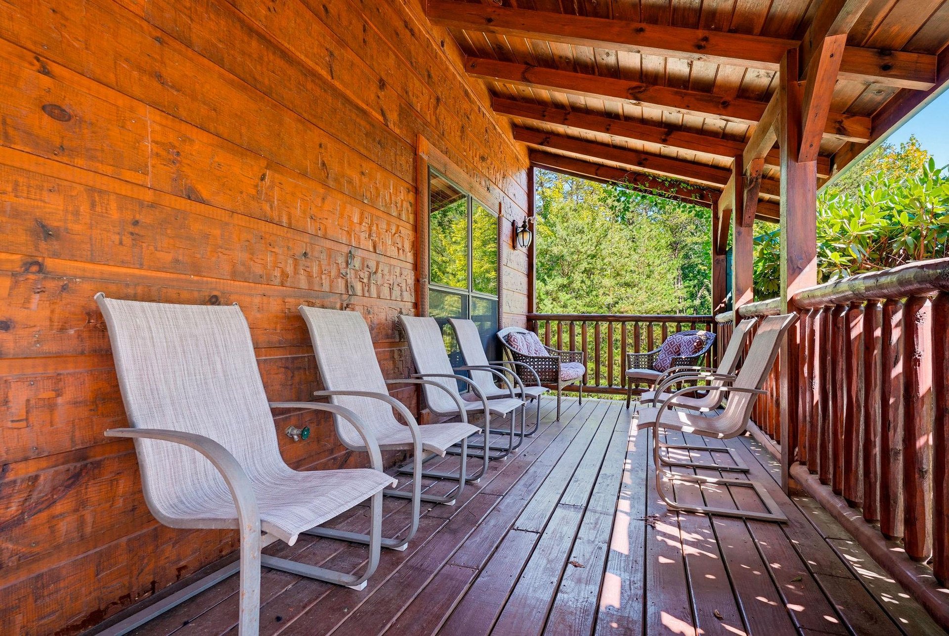 Settle into your own shaded sanctuary, where rows of comfortable seating invite you to unwind and enjoy views of the surrounding greenery from this expansive covered deck.