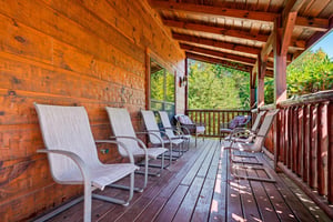 Settle into your own shaded sanctuary, where rows of comfortable seating invite you to unwind and enjoy views of the surrounding greenery from this expansive covered deck.