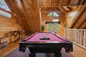 Challenge your family to friendly pool games in this stunning loft game room with soaring wood beams and mountain cabin charm.