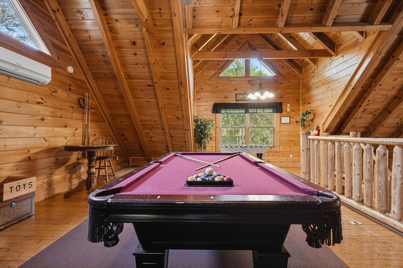 Challenge your family to friendly pool games in this stunning loft game room with soaring wood beams and mountain cabin charm.