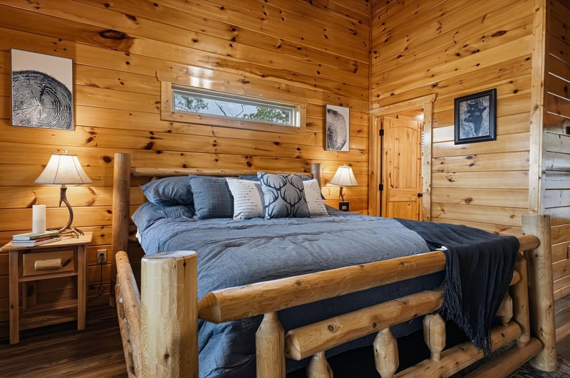 Imagine yourself unwinding in this cozy rustic bedroom, where the warm glow of handcrafted lamps and natural wood walls create a peaceful retreat after your days adventures.