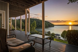 The propertys covered deck overlooks a tranquil lake surrounded by lush forested shoreline, with sunset creating a golden glow across the calm water.