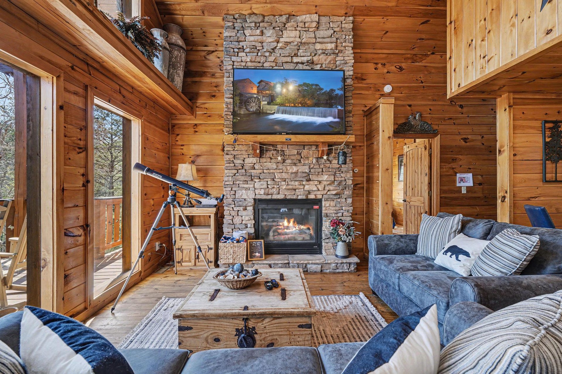 Curl up on plush sofas by your crackling fireplace, where rustic charm meets modern comfort in this cozy living space.