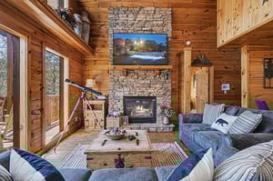 Curl up on plush sofas by your crackling fireplace, where rustic charm meets modern comfort in this cozy living space.
