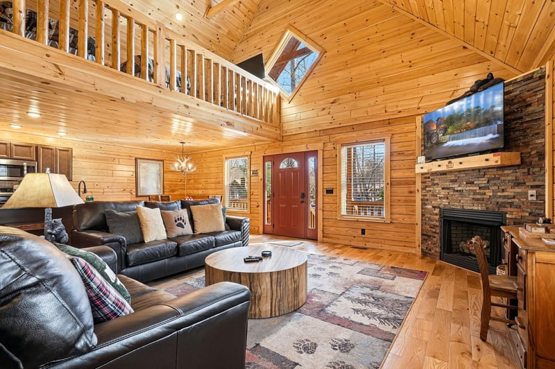 Relax in your cozy cabin living room with plush leather seating, crackling fireplace, and rustic wood details creating the perfect mountain retreat atmosphere.