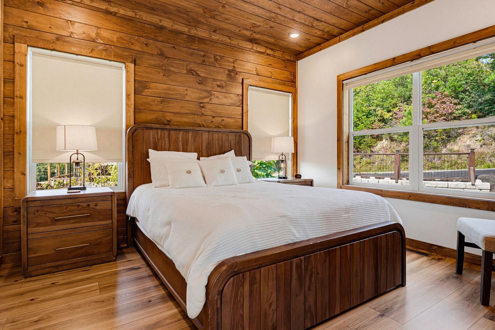 Sink into crisp linens beneath warm wood beams and wake up to lush greenery framed by bright windows—a peaceful retreat designed just for you.