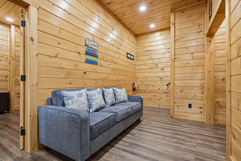 Unwind on the plush sofa in your private woodpaneled retreat, where rustic charm meets modern comfort for the perfect mountain getaway.