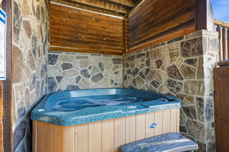 Slip into your private hot tub sanctuary, where rustic stone walls and warm wood beams create the perfect alpine retreat.
