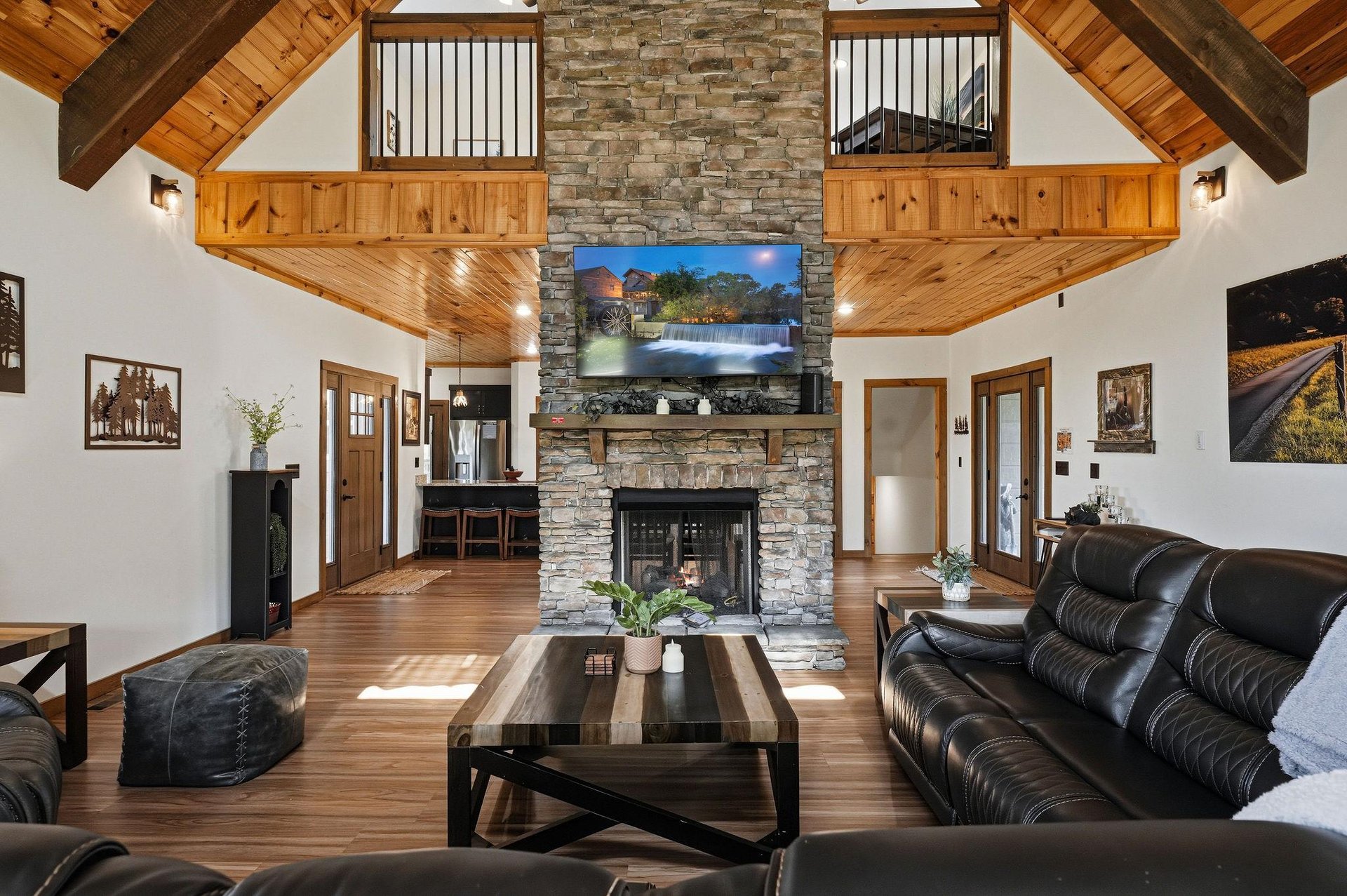 Soaring woodbeamed ceilings and a stunning stone fireplace create a warm, inviting heart of your mountain retreat. Settle into plush leather seating and let the natural beauty surround you.