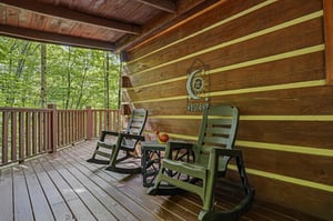 Your covered deck invites you to unwind in rocking chairs, overlooking serene woods where birdsong fills the air and fresh breezes bring pure relaxation.