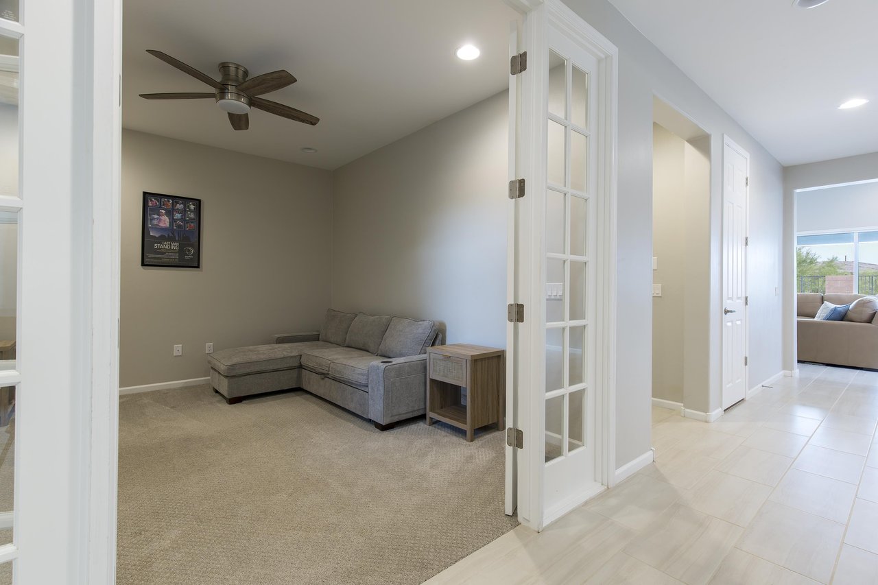Additional living space with sectional couch and TV near the front entryway.