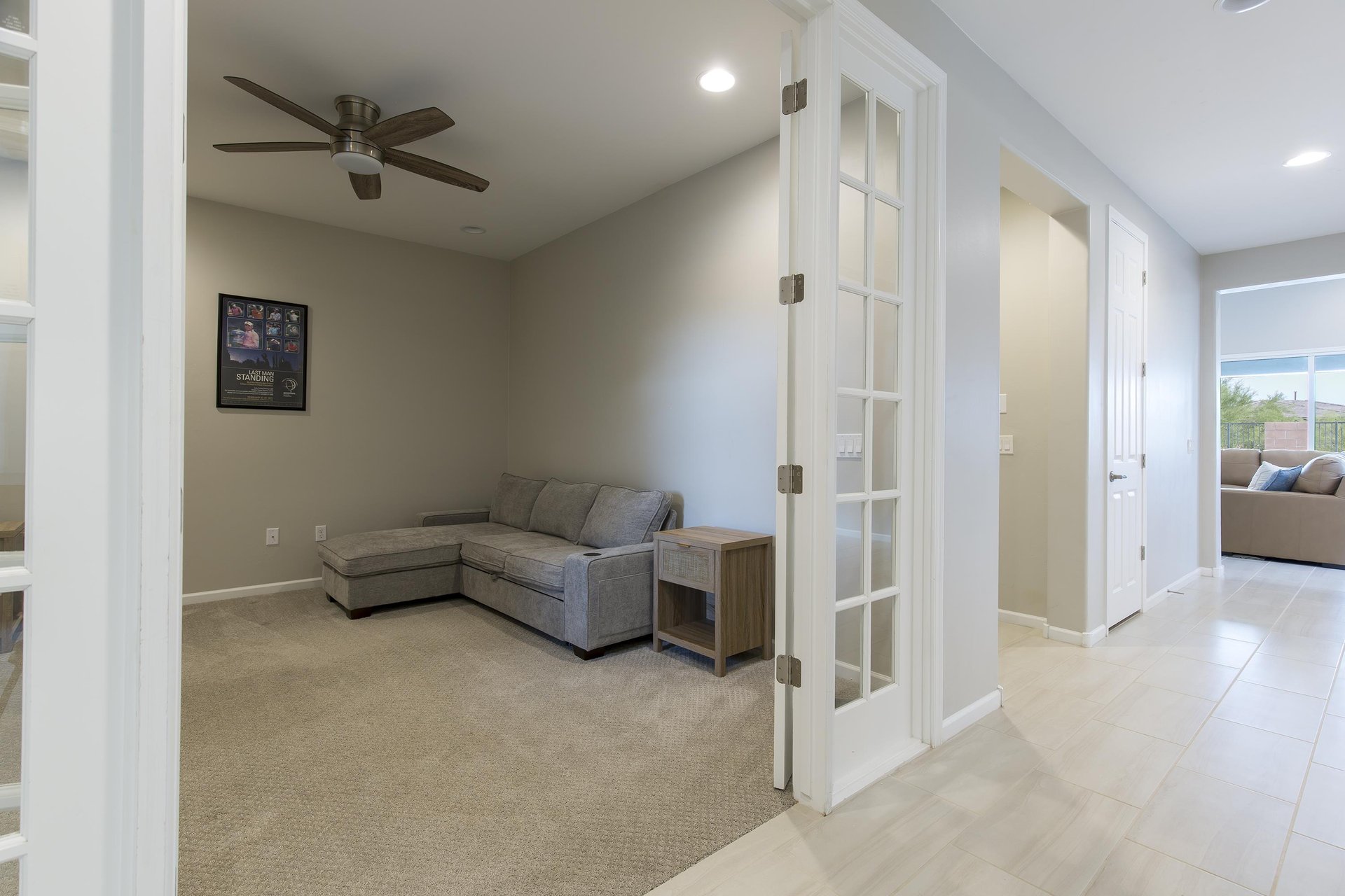 Additional living space with sectional couch and TV near the front entryway.