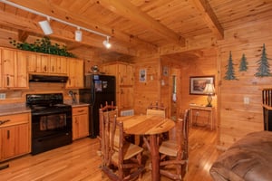 Dining space for four in the kitchen with black appliances at Dreams Do Come True, a 1bedroom cabin rental located in Pigeon Forge