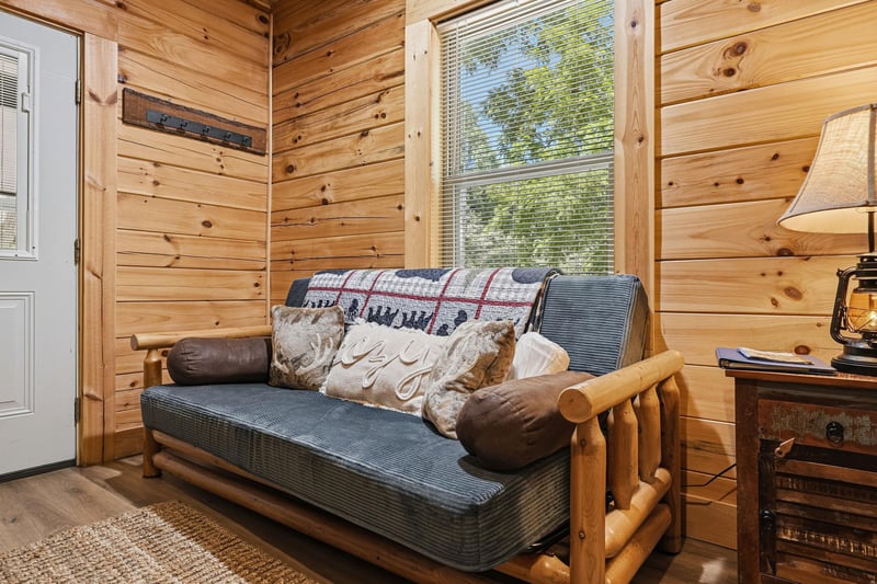 Sink into this cozy log cabin retreat where rustic charm meets modern comfort. Natural light pours through your window, highlighting warm wood walls and inviting you to unwind in style.