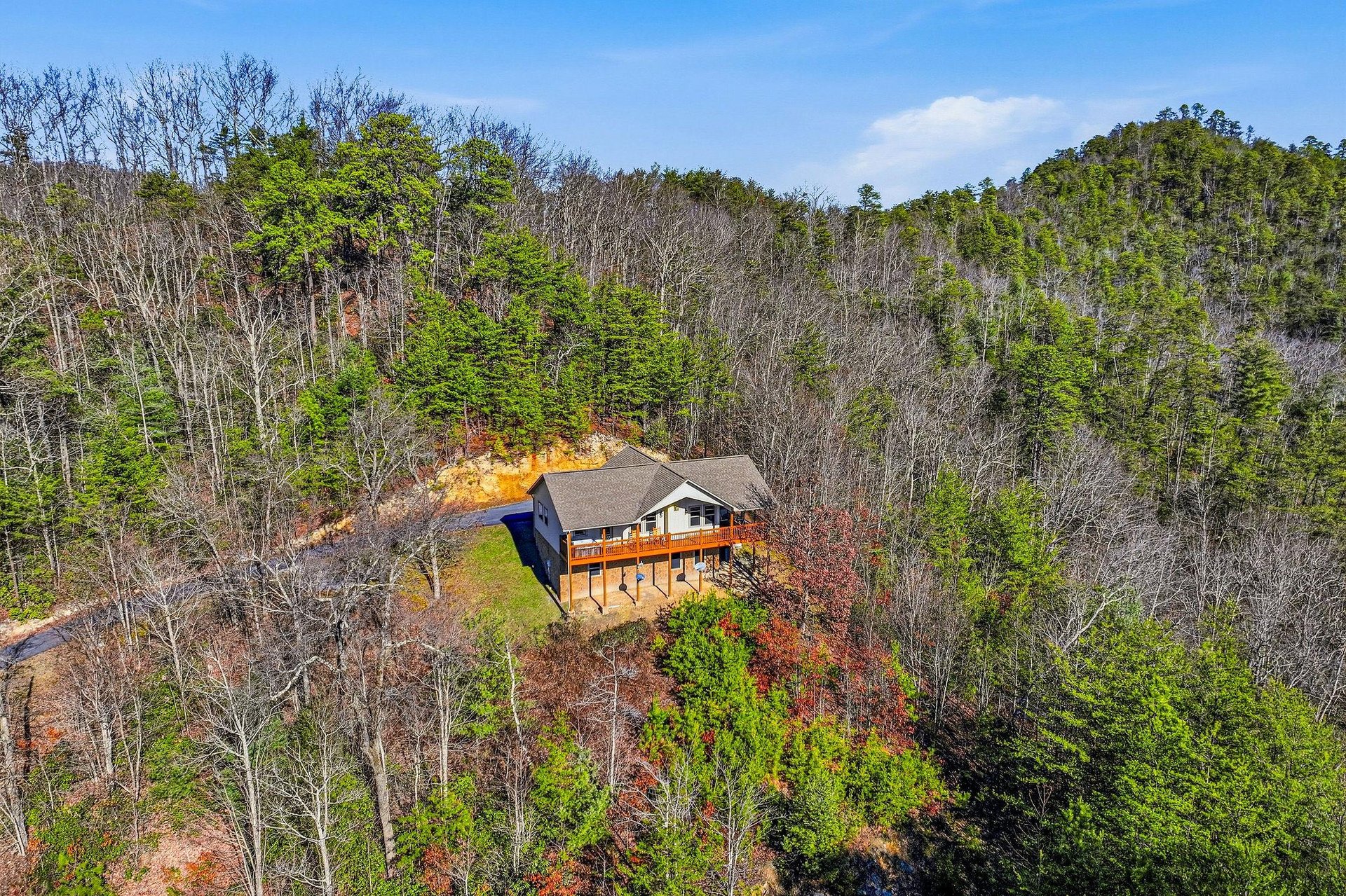 A secluded mountain retreat nestled among rolling hills and vibrant autumn foliage, offering peaceful seclusion in natures embrace.