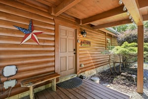 The warm, woodsided cabin entrance greets you with rustic charm and thoughtful touches, hinting at the cozy retreat waiting inside.