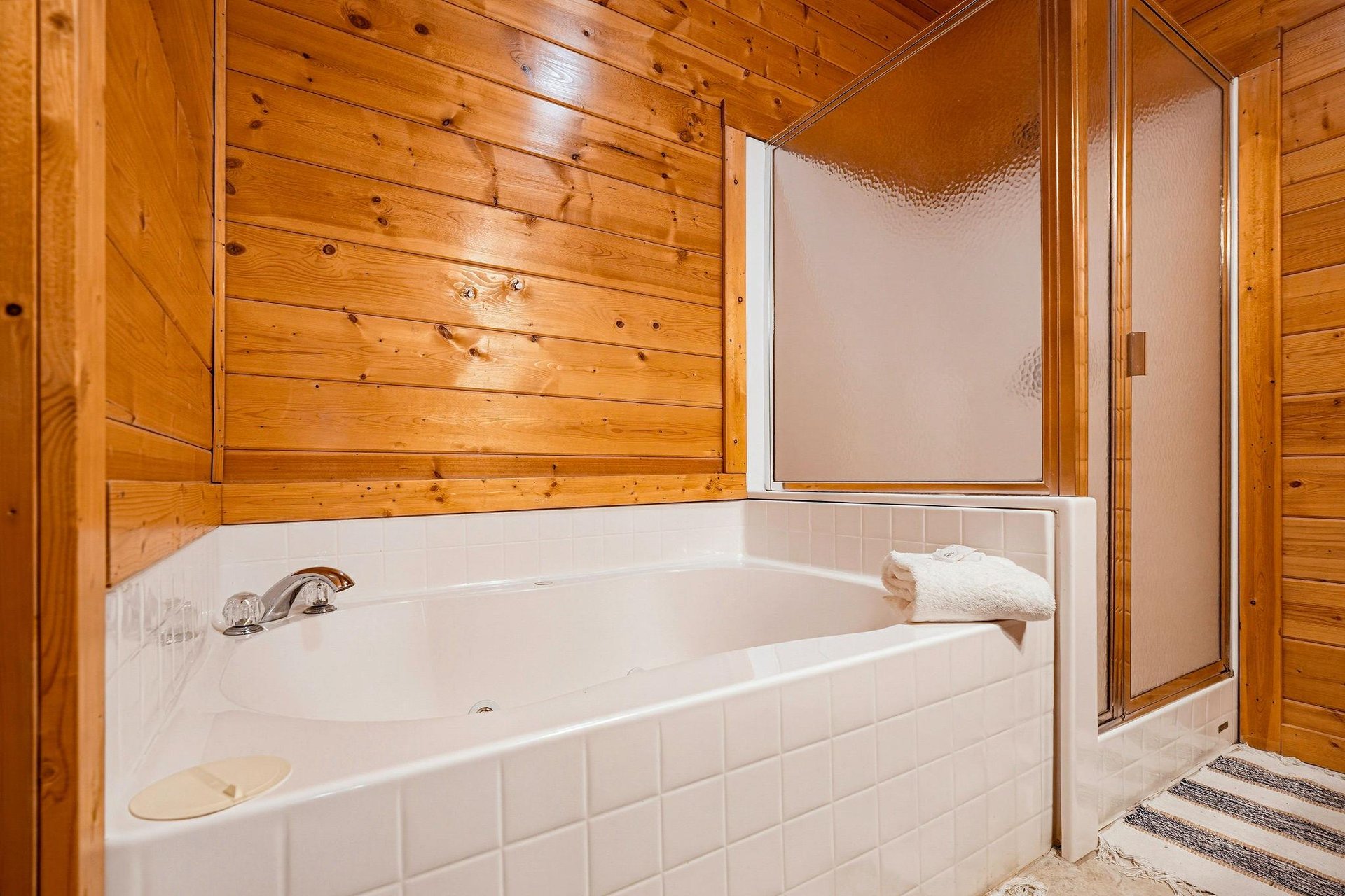Sink into the deep soaking tub after a day of adventure. The warm woodpaneled walls and plush towels create your perfect retreat.