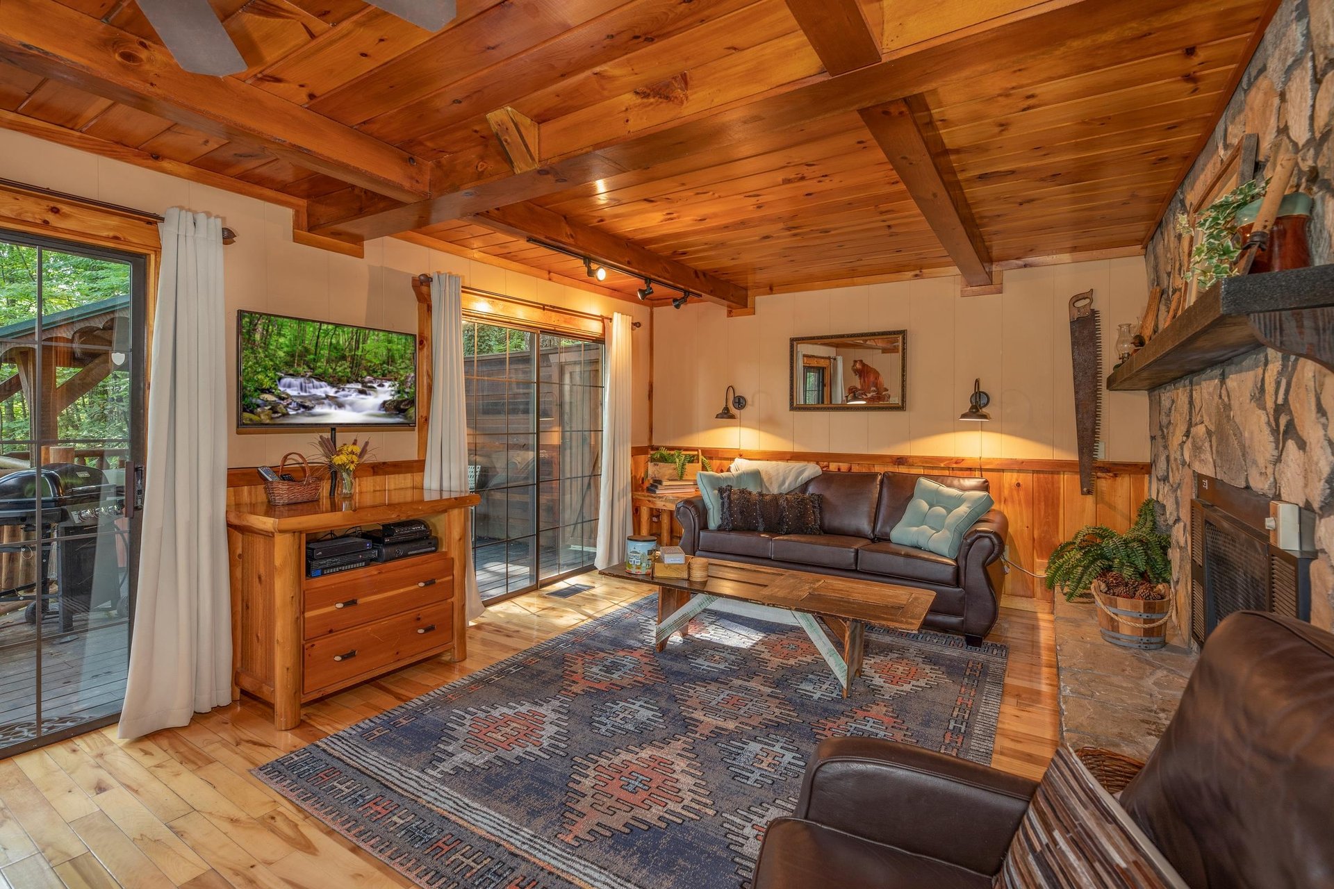Living room with a TV and deck access at Hidden Pleasure, a 1bedroom cabin rental located in Gatlinburg