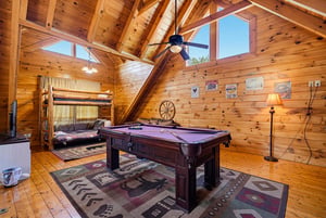 Challenge friends to billiards beneath soaring cathedral ceilings in your private game loft. Sunlight streams through high windows, and rustic bunk beds invite extra guests to join the fun.