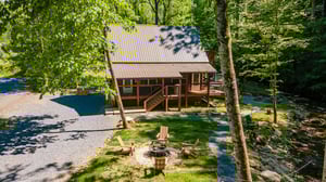 Front of Tridents Creek cabin with firepit and seating area